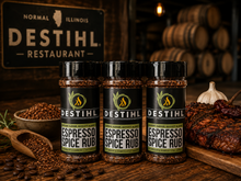 Bottles of DESTIHL Espresso Spice Rub seasoning arranged on a rustic wooden table 