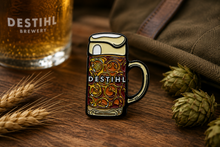 DESTIHL Brewery enamel pin with a glass of beer and hops on wooden surface