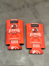 Two red can coolers with 'Redbird Ale' branding on a gray surface